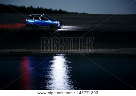 Saratov, Russia - September 28, 2015: Car Subaru Forester stand at countryside off-road and reflected on water at night