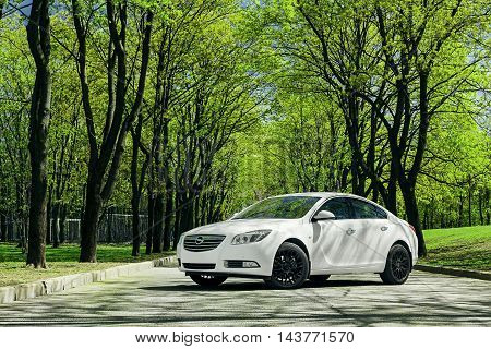 Moscow, Russia - May 07, 2015: Car Opel Insignia stand on asphalt road in green forest at daytime