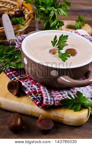 Cream soup of pureed chestnuts on a wooden background. Selective focus.