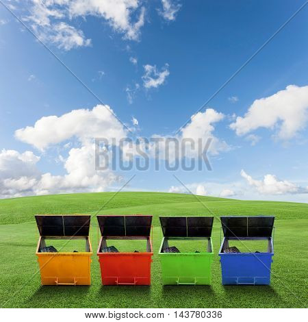 Colorful Industrial Waste Bin (dumpster) for municipal waste or industrial waste on green grass and blue sky backgroundwith ecology concept