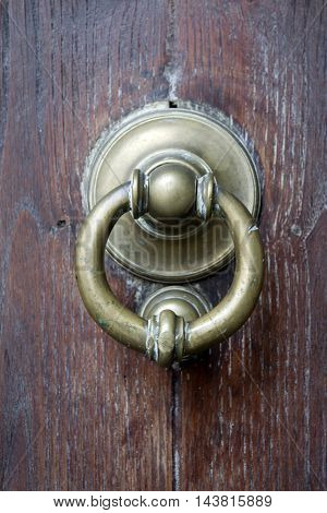 old brass knocker on a ancient wooden main door