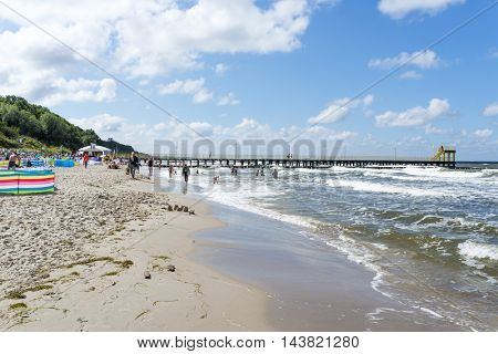 USTRONIE MORSKIE - AUGUST 15: Tourists enjoy the sunny weather and relaxing on the Baltic sea beach on 15 August 2016 in Ustronie Morskie, Poland.