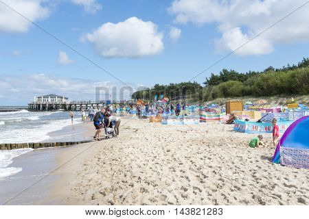 USTRONIE MORSKIE - AUGUST 15: Tourists enjoy the sunny weather and relaxing on the Baltic sea beach on 15 August 2016 in Ustronie Morskie, Poland.