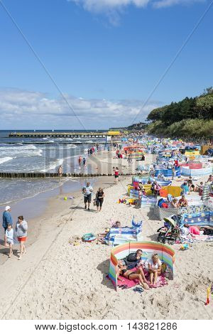 USTRONIE MORSKIE - AUGUST 15: Tourists enjoy the sunny weather and relaxing on the Baltic sea beach on 15 August 2016 in Ustronie Morskie, Poland.