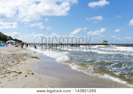 USTRONIE MORSKIE - AUGUST 15: Tourists enjoy the sunny weather and relaxing on the Baltic sea beach on 15 August 2016 in Ustronie Morskie, Poland.