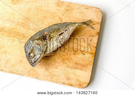 mackerel fried on a wooden cutting board with white background isolated.