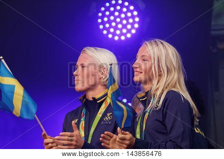 STOCKHOLM SWEDEN - AUG 21 2016: Happy swedish female wrestler Jenny Fransson and Sofia Mattson waiving a flag when swedish olympic athletes are celebrated in Kungstradgarden StockholmSwedenAugust 212016