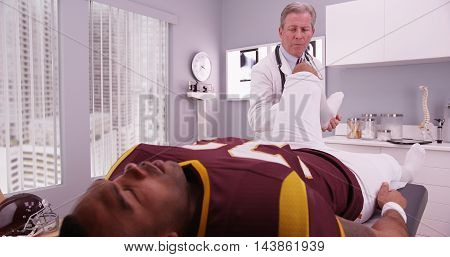 Mid-aged Physical Therapist Examining College Athlete Sports Injury