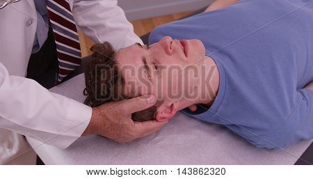 Young Adult Male Having Neck Injury Examined By Chiropractor