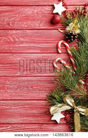 Christmax Tree Branch With Baubles, Candies On Red Wooden Table