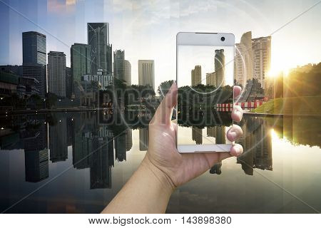 Hand holding white phone with city scape and wifi network connection concept .