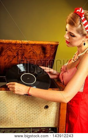 Girl in style keeps vinyl record. Pin-up retro female style. Girl pin-up style wearing red dress