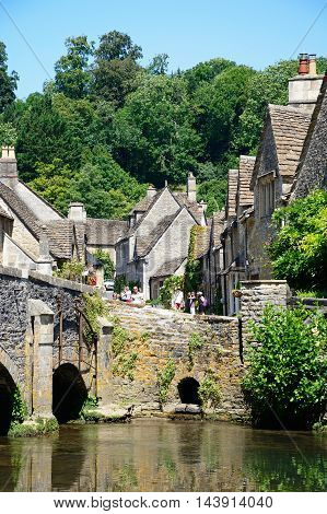 CASTLE COMBE, UNITED KINGDOM - JULY 20, 2016 - Stone bridge over the river Bybrook with cottages to the rear Castle Combe Wiltshire England UK Western Europe, July 20, 2016.