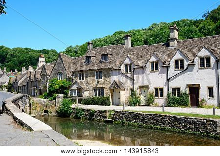 Stone cottages alongside the river Bybrook Castle Combe Wiltshire England UK Western Europe.