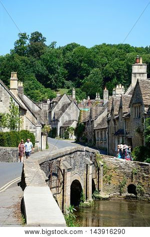 CASTLE COMBE, UNITED KINGDOM - JULY 20, 2016 - Stone bridge over the river Bybrook with cottages to the rear Castle Combe Wiltshire England UK Western Europe, July 20, 2016.