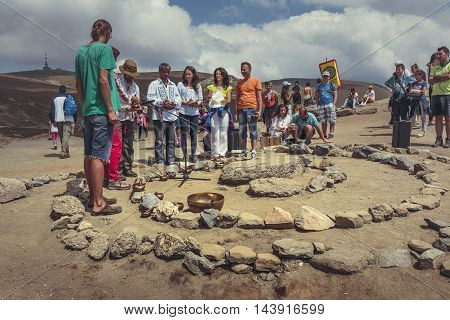 Bucegi Mountains Romania - August 6 2016: People attend a spiritual ritual organized around a spiral of stones near the Sphinx the sacred megalith located at 2216 m altitude in Bucegi Mountains.