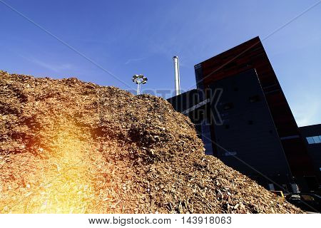 Bio Power Plant With Storage Of Wooden Fuel Against Blue Sky