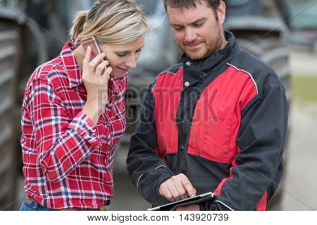 Farmer and technician working together with electronics