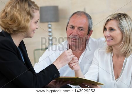 senior couple negociating with businesswoman for new investment