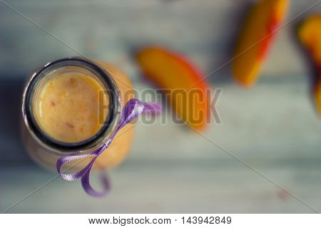 Peaches and smoothie on white wooden background