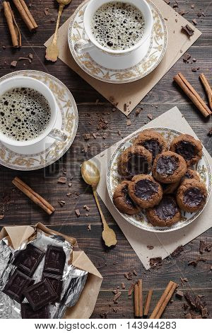 A plate of chocolate homemade cookies and two cups of coffee