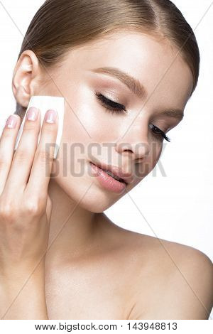 Beautiful young girl with wipes for removing makeup and French manicure. Beauty face. Picture taken in the studio on a white background.