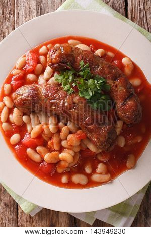 Pork Sausages With Beans And Cooked Tomatoes On A Plate Closeup. Vertical Top View
