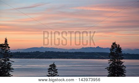 Sunset on the USA and Canadian border viewed from Point Whitehorn Birch Bay Washington looking at Birch Point across the water and Canada in the distance