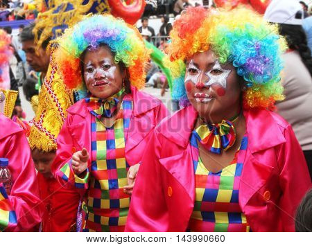 Cajamarca Peru - February 7 2016: Close up of two women in colorful clown costumes marching in Carnival parade in Cajamarca Peru on February 7 2016