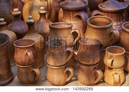 Ceramic tableware handmade clay in natural sunlight: cups bottles jars