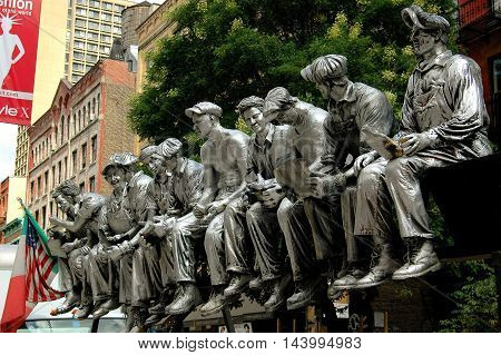 New York City - August 22 2004: Sculpture of iron workers having lunch sitting on a beam during the 1932 construction of Rockefeller Center displayed on West Broadway in Soho