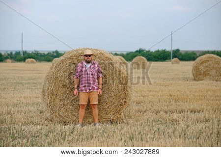 Man Resting After Hay Harvesting In Haystacks