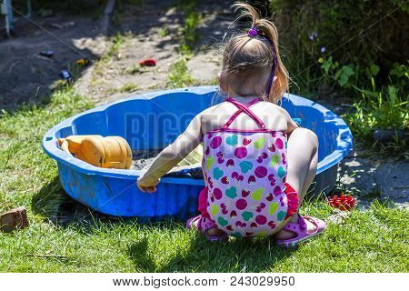 Adorable Little Girl Playing In A Sandbox.