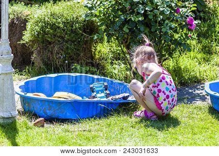 Adorable Little Girl Playing In A Sandbox.