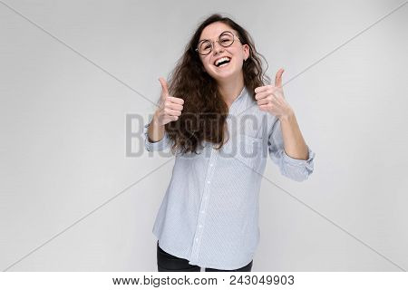 A Young Girl In A Light Blouse And Dark Trousers. The Girl Is Laughing.