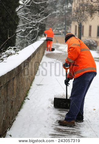 Snow Spreader With High Visibility Jacket Shovels The Sidewalks After The Heavy Snowfall In Winter