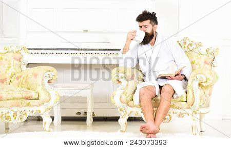 Man With Beard And Mustache Enjoys Morning While Sitting On Luxury Armchair. Elite Leisure Concept. 