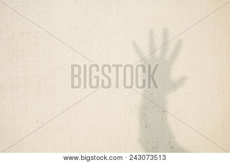 Shadow Of Human Hand On Abstract Wall