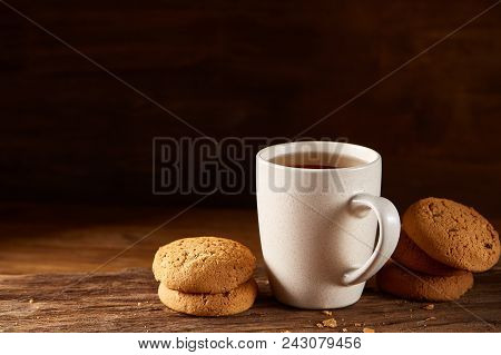 White Porcelain Mug Of Black Tea Or Earl Grey And Pile Of Sweet Cookies On Flat Piece Of Wood Over R