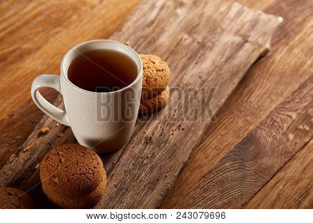 White Porcelain Mug Of Black Tea Or Earl Grey And Pile Of Sweet Cookies On Flat Piece Of Wood Over R