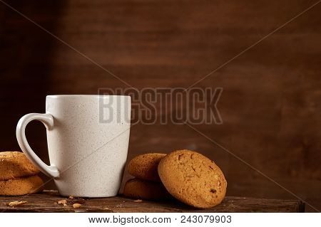 White Porcelain Mug Of Black Tea Or Earl Grey And Pile Of Sweet Cookies On Flat Piece Of Wood Over R