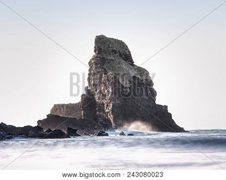 Sharp Silhouette Of A Cliff Against The Background Of Sunset. Sea Waves Break On The Rocks. Talisker