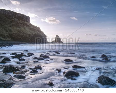 Blue Sunset At Rocky Coast Of Sea. Slow Shutter Speed For Smooth Water Level And Dreamy Effect
