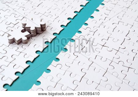 The Blue Path Is Laid On The Platform Of A White Folded Jigsaw Puzzle. The Missing Elements Of The P