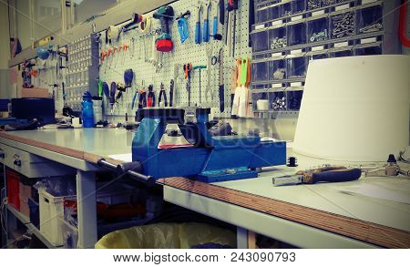 Interior Of A Mechanical Workshop For The Repair Of Bicycles And A Large Blue Vise  With Vintage Eff