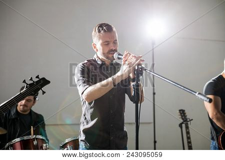 Hispanic Male Lead Singer Singing A Melodious Song Live In A Music Concert