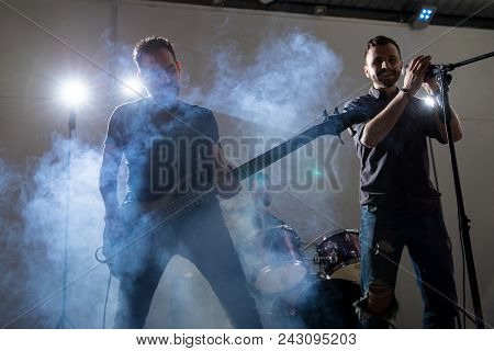 Male Lead Singer With Guitarist On Stage At Music Concert
