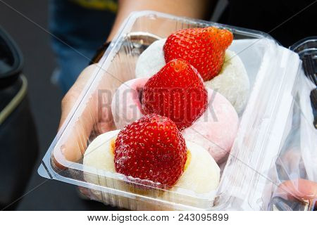 Closeup Red Strawberry On Moji And On Hand