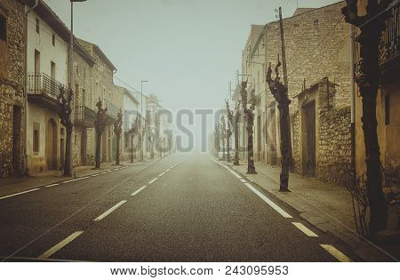 Uninhabited Street In The Fog With The City Of Tarin. Photo With The Effect Of Noise.