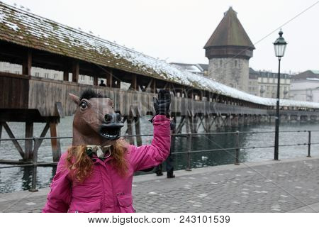 Girl With The Head Of A Horse At The Chapel Bridge In Lucerne In Switzerland